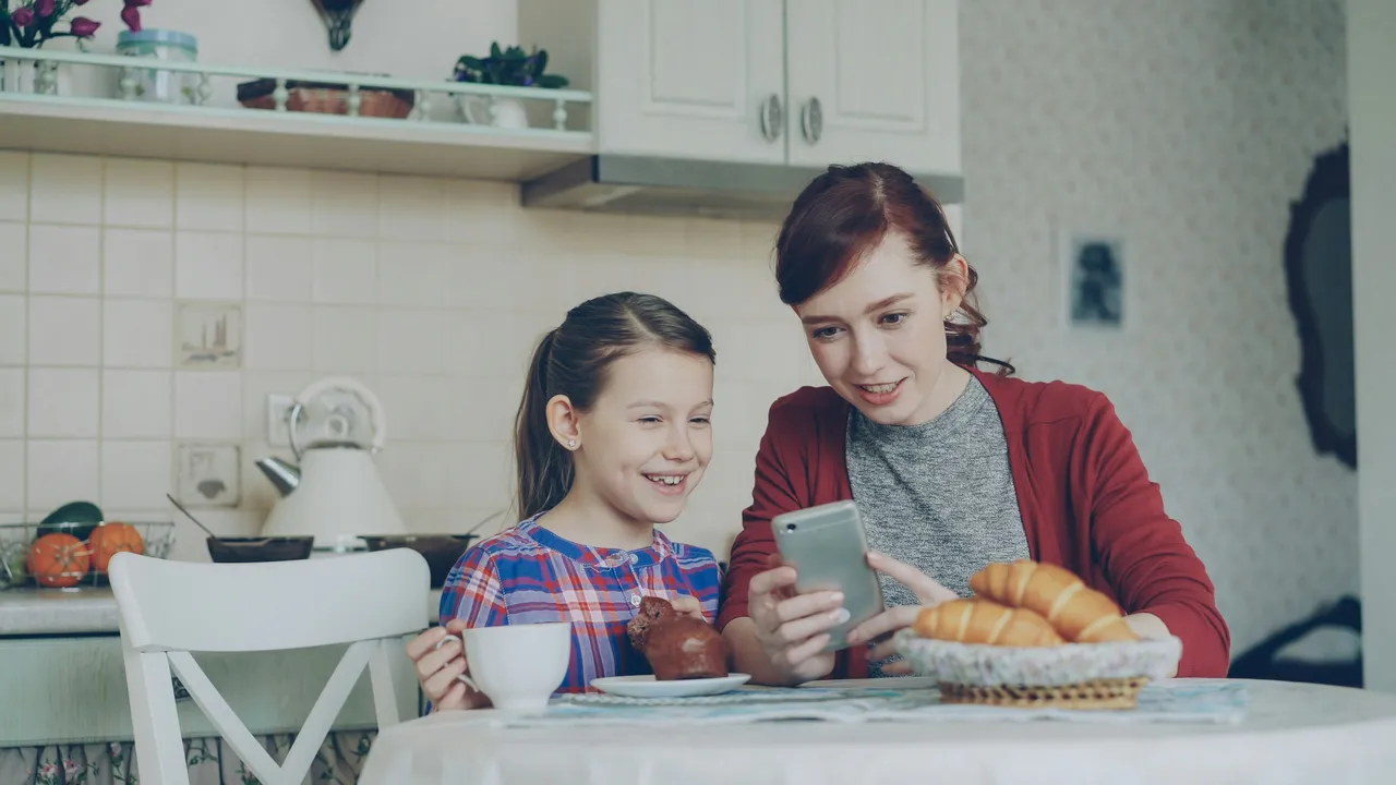 Une mère et sa fille découvrent Harmonia sur un téléphone