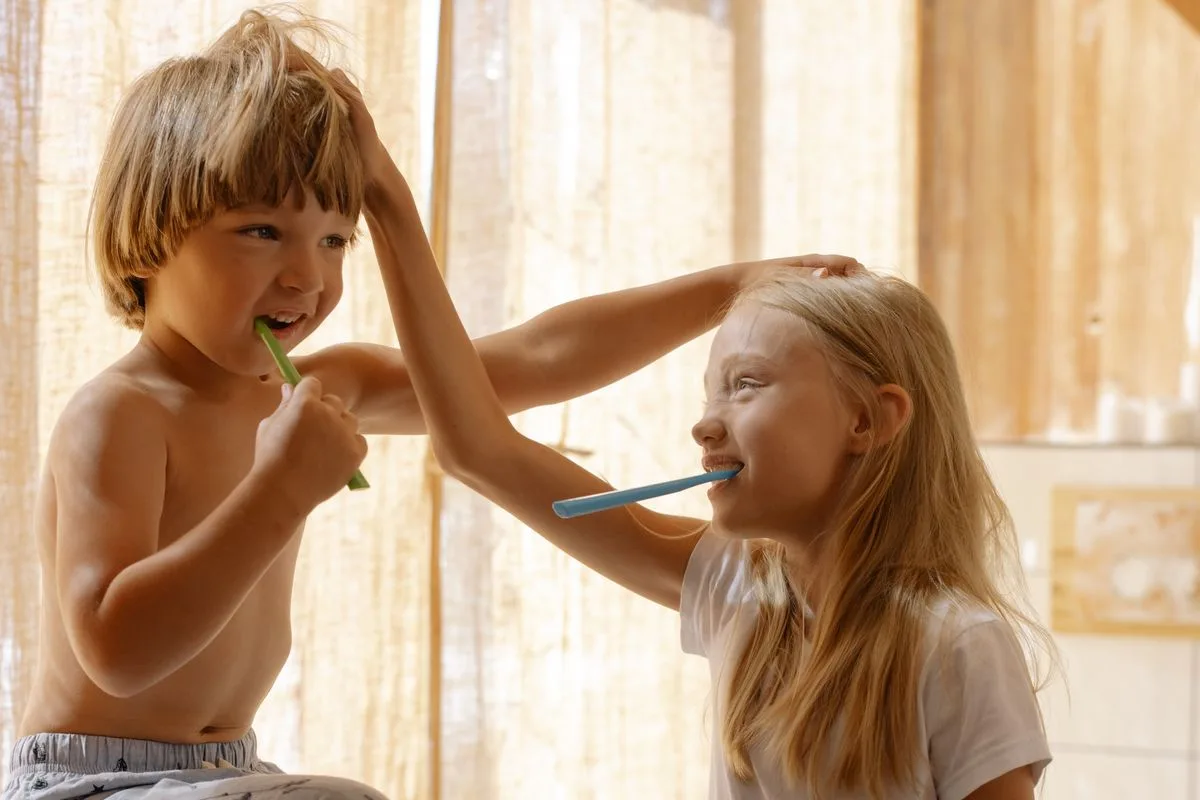 Deux enfants se brossent les dents en se chamaillant